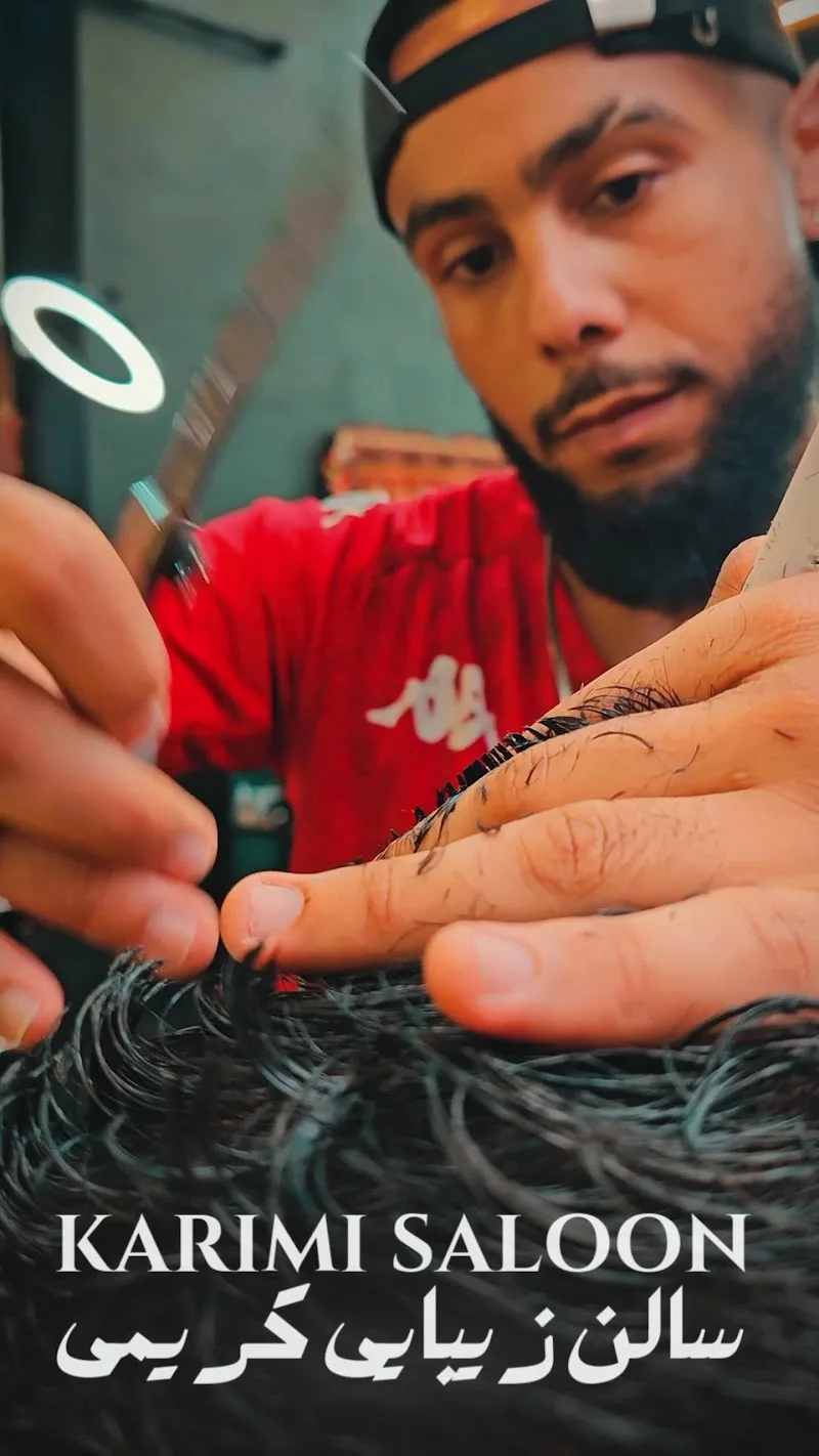 A barber at Karimi Saloon cutting a client's hair